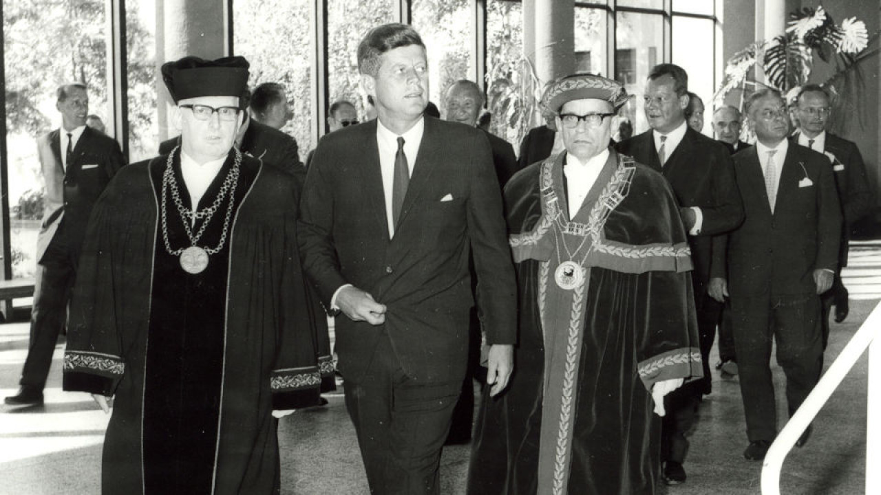 JF Kennedy mit Talarträgern 1963 im Foyer des Henry-Ford Baus