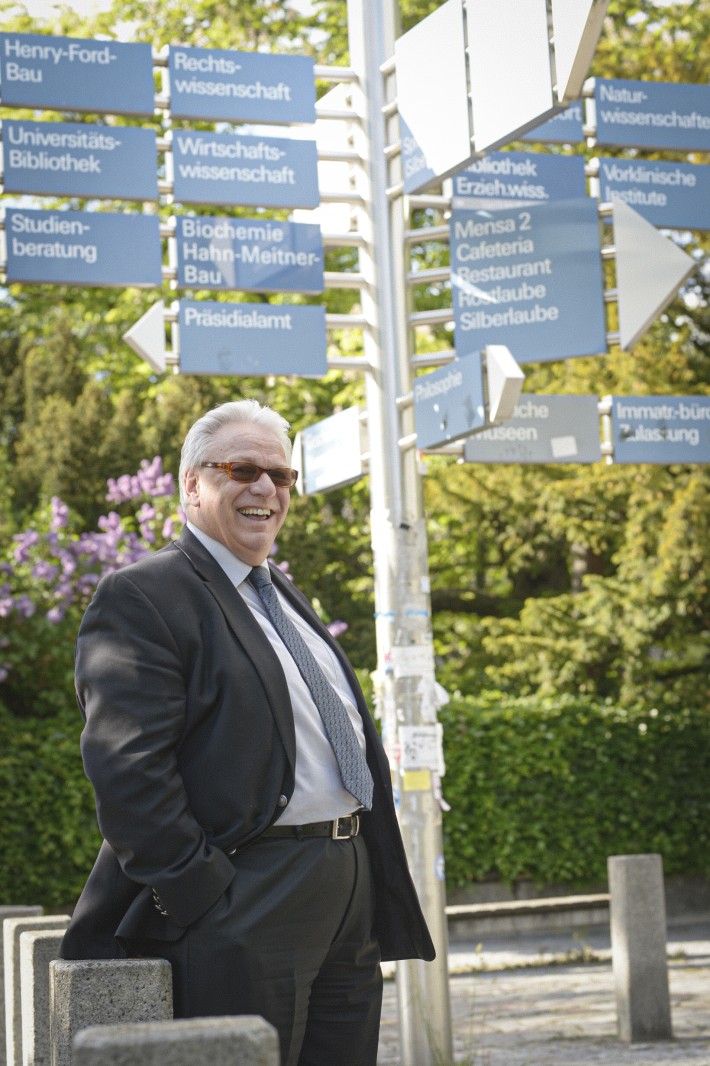 Dr. Wedigo de Vivanco vor dem Wegweiserwald der Freien Universität Berlin